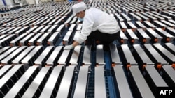 FILE - This photo taken March 12, 2021, shows a worker with car batteries at a factory for Xinwangda Electric Vehicle Battery Co. Ltd., which makes lithium batteries for electric cars and other uses, in Nanjing, Jiangsu province, China. 