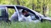 Policijski forenzičar uzima dokaze iz automobila u selu Dubona, 50-ak kilometara južno od Beograda, u petak, 5. maja 2023, nakon druge masovne pucnjave u dva dana.