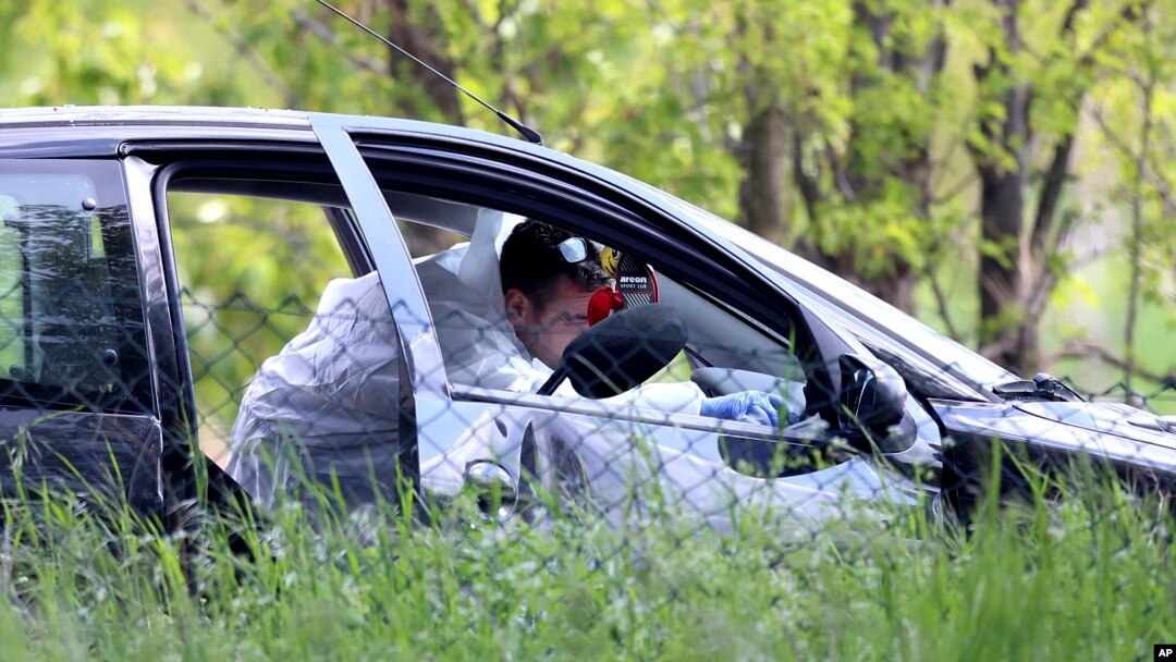 Policijski forenzičar uzima dokaze iz automobila u selu Dubona, 50-ak kilometara južno od Beograda, u petak, 5. maja 2023, nakon druge masovne pucnjave u dva dana.