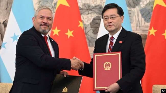 에두아르도 엔리케 레이나(왼쪽) 온두라스 외무장관과 친강 중국 외교부장 겸 국무위원이 26일 베이징에서 외교관계 수립에 관한 공동성명에 서명한 뒤 악수하고 있다.