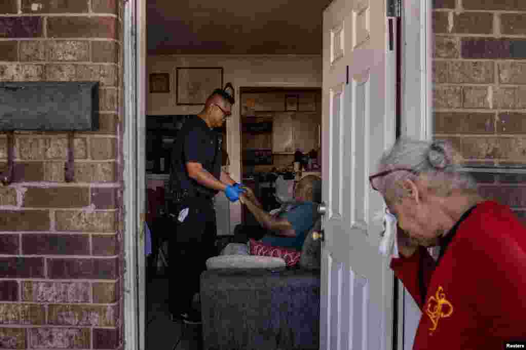 McNeese, 67, reacts as Eric Bailon, a paramedic with the Galveston County Health District, assesses her partner Jordan, 85, after medics say he overheated and fell in his kitchen during a heat wave in Galveston, Texas, Aug. 27, 2023. REUTERS/Adrees Latif&nbsp;