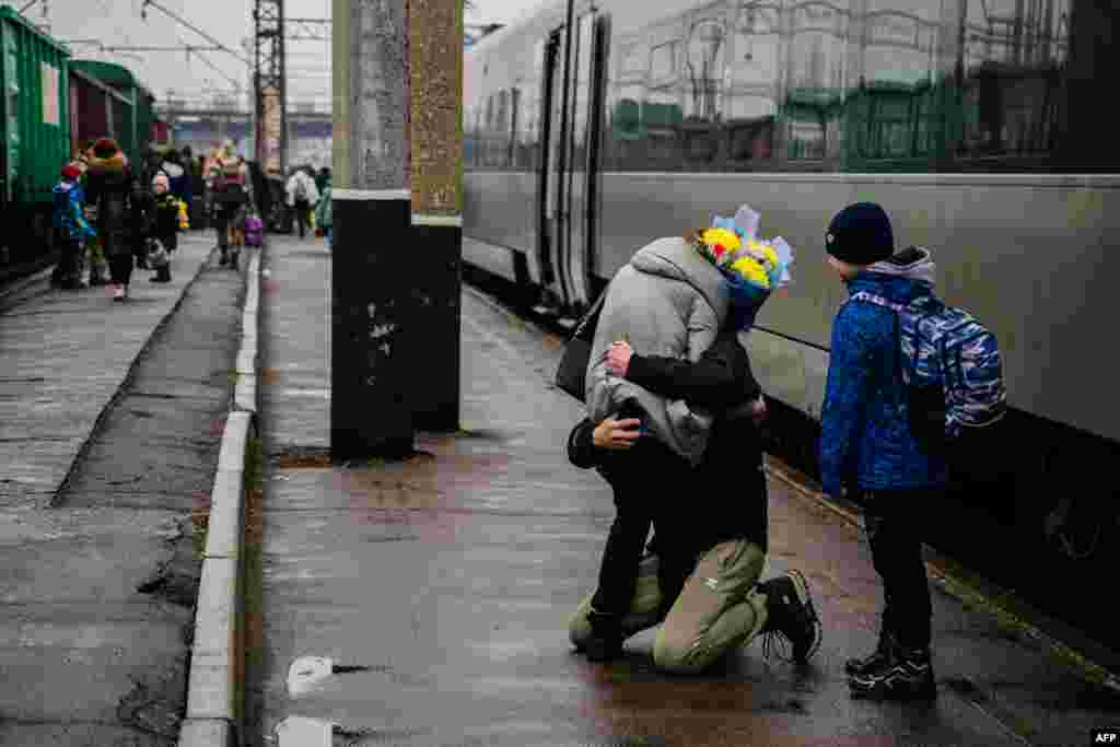 A Ukrainian man welcomes his family upon their arrival from Kyiv at the train station in Kramatorsk.