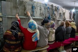 FILE - Gadis-gadis Afghanistan menenun karpet di sebuah pabrik karpet tradisional di Kabul, Afghanistan, Senin, 6 Maret 2023. (AP/Ebrahim Noroozi)