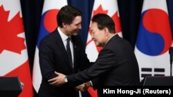 Perdana Menteri Kanada Justin Trudeau berjabat tangan dengan Presiden Korea Selatan Yoon Suk Yeol setelah konferensi pers bersama setelah pertemuan mereka di Kantor Kepresidenan di Seoul, Korea Selatan, 17 Mei 2023. (Foto: REUTERS/Kim Hong-Ji)