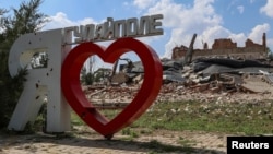 A city sign 'I love Hulyaipole' is seen near a building destroyed in a Russian military strike in Hulyaipole, Zaporizhzhia region, Ukraine, Sept. 3, 2023.