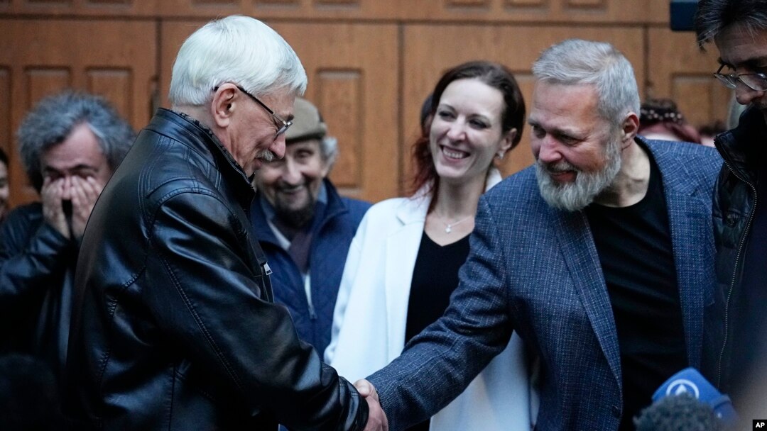 Nobel Peace Prize-winning journalist Dmitry Muratov, right, shakes hands with Oleg Orlov, co-chair of the Nobel Prize-winning Russian human rights organization Memorial after a court session in Moscow, Oct. 11, 2023.