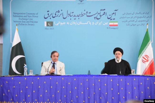 Iran's President Ebrahim Raisi and Pakistan Prime Minister Shehbaz Sharif jointly inaugurate a market and power transmission line, along their shared border, May 18, 2023. (Photo courtesy of Sharif office)
