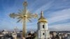 Dos hombres instalan una cruz restaurada en la cúpula de la Catedral de Santa Sofía en Kiev, Ucrania, el 21 de diciembre de 2023.