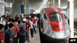 Masyarakat berfoto dengan gerbong pertama Kereta Cepat Jakarta-Bandung (KCJB) saat tahap uji coba umum selama seminggu di Stasiun Tegalluar, Bandung, Jawa Barat, 17 September 2023. (Yasuyoshi CHIBA / AFP)