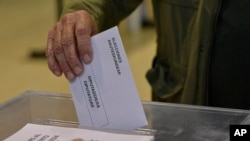 Um eleitor deposita o seu voto numa assembleia de voto em Pamplona, no norte de Espanha, no domingo, 9 de junho de 2024.