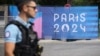 Seorang petugas polisi berjalan melewati spanduk Olimpiade Paris pada Olimpiade Musim Panas 2024, Sabtu, 20 Juli 2024, di Paris, Prancis. (Foto: AP)