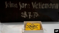 Yellow badges and a piece of luggage are displayed at Yad Vashem World Holocaust Remembrance Center in Jerusalem, July 8, 2024.