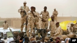 FILE - Sudanese soldiers from the Rapid Support Forces unit stand on a vehicle during a military-backed rally south of Khartoum, Sudan, June 29, 2019. On Saturday, the group endorsed a resolution by the U.N. Security Council calling for a cease-fire during Ramadan.