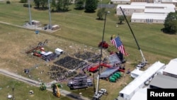 FILE - A drone view shows the stage where Republican presidential candidate and former president Donald Trump was standing during an assassination attempt the day before, and the roof of a nearby building where a gunman was shot dead, in Butler, Pennsylvania, July 14, 2024. 