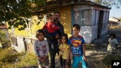 Nidal Jumaa, a Syrian from Aleppo, is pictured with his children outside their house in Ankara, Nov. 9, 2022. Syrians fleeing their country's civil war were once welcomed in Turkey; now, the question of what to do about them has become divisive.