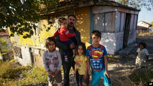 Nidal Jumaa, a Syrian from Aleppo, is pictured with his children outside their house in Ankara, Nov. 9, 2022. Syrians fleeing their country's civil war were once welcomed in Turkey; now, the question of what to do about them has become divisive.