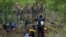 Seorang migran berhadapan dengan sejumlah petugas keamanan Texas di tepi sungai Rio Grande di Meksiko, pada 11 Mei 2023. (Foto: AP/Fernando Llano)