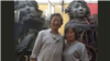 中国艺术家严正学(左)在其雕塑作品前拍照（照片来自高瑜推特）