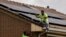 FILE - Workers install solar panels on the roof of a house in Rivas Vaciamadrid, Spain, Sept. 15, 2022. 