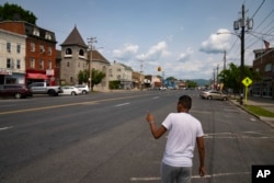 Mohamed of Mauritania, points in the direction of his prospective work opportunity, May 22, 2023, in Newburgh, N.Y.