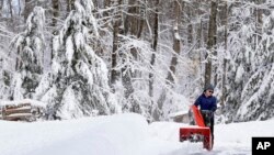 Meghan Hall limpia la nieve de su entrada después de una tormenta de invierno, el miércoles 15 de marzo de 2023, en Polonia, Maine. La tormenta arrojó nieve pesada y húmeda en partes del noreste, lo que provocó decenas de miles de cortes de energía. (Foto AP/Robert F. Bukaty)