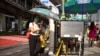 People carry umbrellas and hand-made fans to cool down from the extreme heat in Bangkok, Thailand, April 23, 2023.