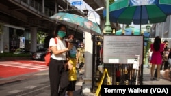 泰国曼谷的行人在飙升的酷热中打阳伞遮蔽阳光。（2023年4月23日）