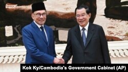 លោក​នាយករដ្ឋមន្ត្រី ហ៊ុន សែន (ស្ដាំ) ចាប់​ដៃ​ជាមួយ​សមភាគី​ម៉ាឡេស៊ី​របស់​លោក​គឺលោក​​នាយករដ្ឋមន្ត្រី Anwar Ibrahim ក្នុង​អំឡុងពេល​លោក​ធ្វើ​ទស្សនកិច្ច​នៅ​រាជធានី​ភ្នំពេញ ថ្ងៃទី ២៧ ខែមីនា ឆ្នាំ២០២៣។ (Kok Ky/Cambodia's Government Cabinet via AP)