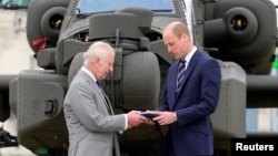 Britain's King Charles III officially hands over the role of Colonel-in-Chief of the Army Air Corps to Prince William, in front of a helicopter at the Army Aviation Centre in Middle Wallop, Britain, May 13, 2024.