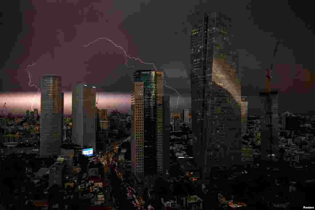 An Israeli flag is seen as lightning strikes over the sky in Tel Aviv, Israel.