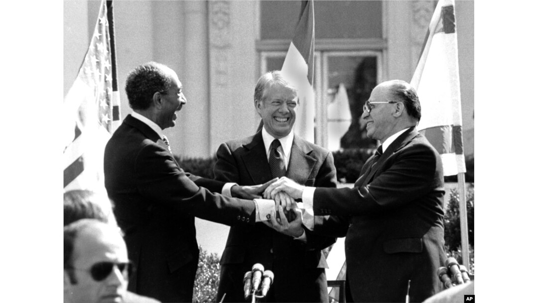 El presidente egipcio Anwar Sadat, el presidente estadounidense Jimmy Carter y el primer ministro israelí Menachem Begin se dan la mano en el jardín norte de la Casa Blanca después de firmar el tratado de paz entre Egipto e Israel en Washington, el 26 de marzo de 1979.