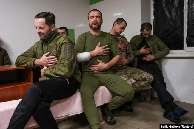 Ukrainian service members do exercises during a stress control class, November 17, 2023. (REUTERS/Sofiia Gatilova)