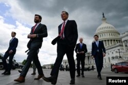 FILE - U.S. senators walk to a press conference to call on U.S. President Joe Biden to negotiate with Republicans in order to make a deal on raising the debt ceiling on Capitol Hill in Washington, May 3, 2023.