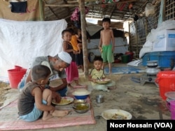 A Rohingya family eats at their shanty in Cox's Bazar camp, Bangladesh, March 18, 2023. (Noor Hossain/VOA)