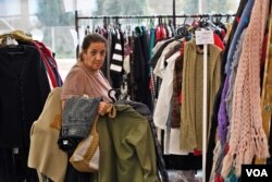 Una mujer selecciona ropa que se distribuye gratis a los evacuados por la guerra entre Israel y Hamás.