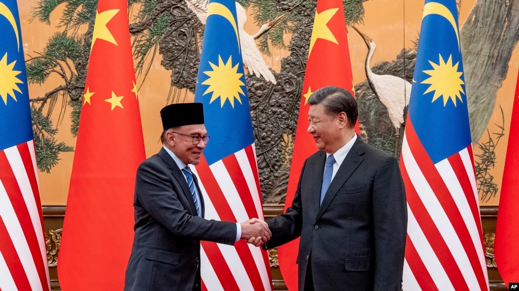 资料图片:在马来西亚总理办公室发布的这张照片中，马来西亚总理安瓦尔(左)于2003年3月31日在北京人民大会堂与中国国家主席握手。(Sadiq Asyraf/Prime Minister's Office of Malaysia via AP)(photo:VOA)