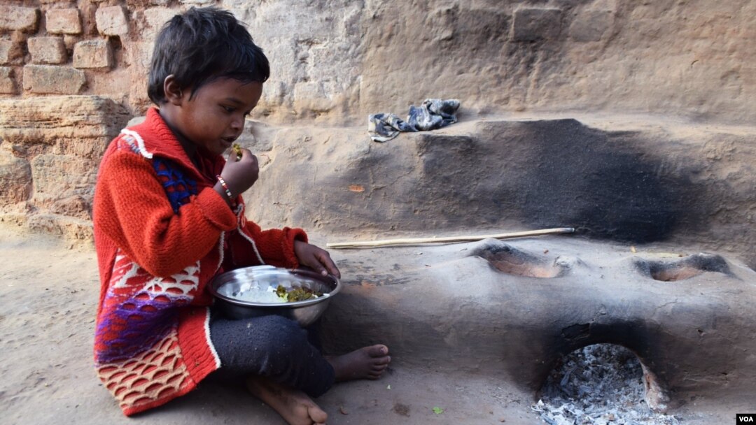 A young tribal girl in Jharkhand sits down for a meal. Impoverished and starved, girls from tribes in remote parts of India often become targets for human traffickers. (Arti Munda for VOA)