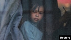 Un niño mira por la ventana de un autobús mientras los civiles evacuados de la región ucraniana de Jersón, controlada por Rusia, llegan a una estación de tren local, en la ciudad de Dzhankoi, en Crimea, Ucrania, el 2 de noviembre de 2022.