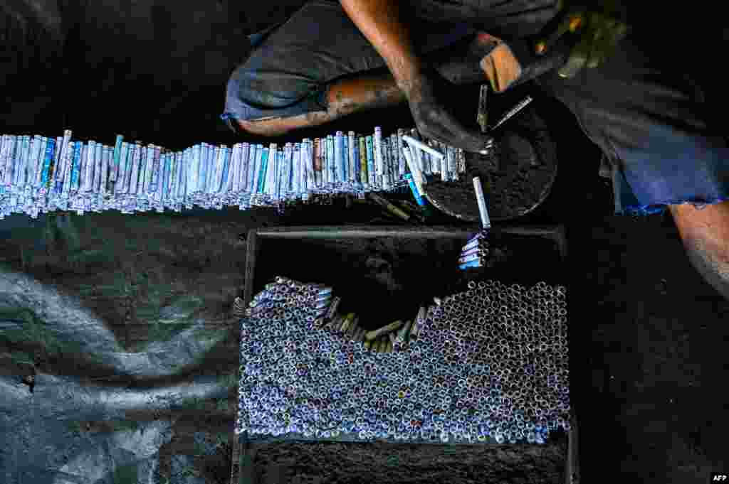 A worker makes firecrackers in the village of Kimbulapitiya on the outskirts of Colombo, Sri Lanka, ahead of the Sinhala and Tamil New Year celebrations. (Photo by Ishara S. KODIKARA / AFP)