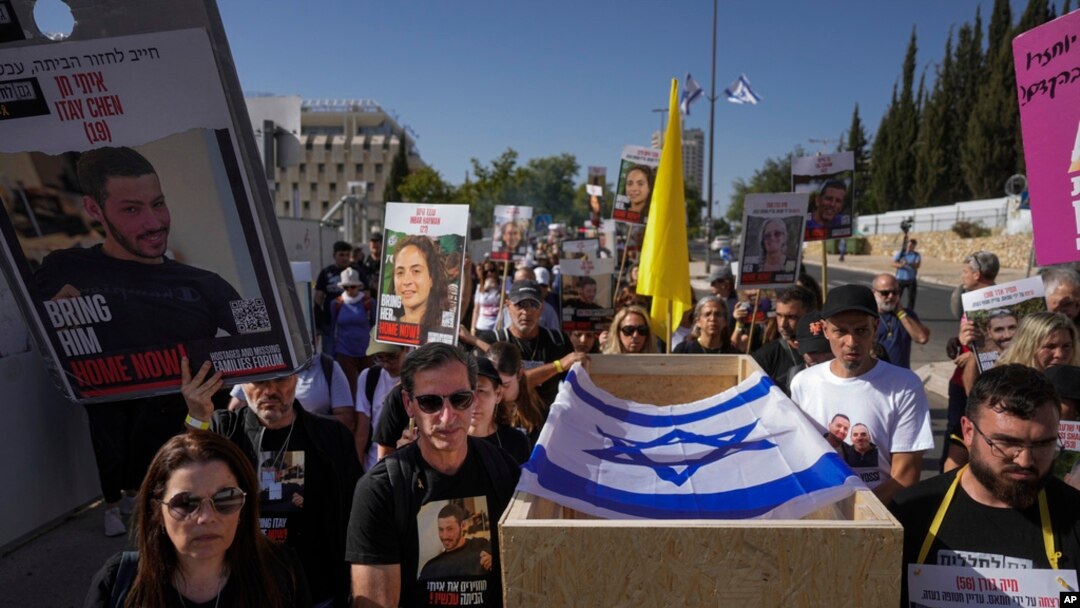 Hagit and Ruby Chen, left, carry an empty casket during a mock funeral for Israelis whose remains are being held by Hamas militants in the Gaza Strip, near the Israeli parliament building in Jerusalem, May 9, 2024. 