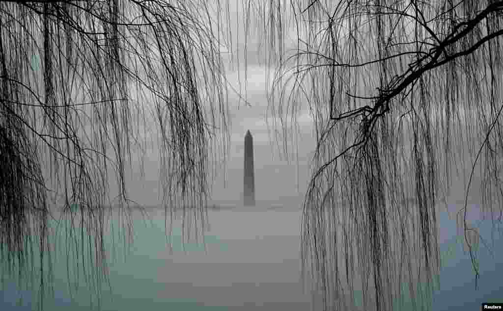 The Washington Monument rises above fog blanketing the Potomac River on an unseasonably warm day in Washington.