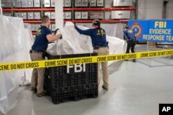 In this image provided by the FBI, FBI special agents process material recovered from the high altitude balloon recovered off the coast of South Carolina, Thursday, Feb. 9, 2023, at the FBI laboratory in Quantico, Va., (FBI via AP)