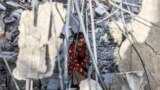 A girl salvages items from the rubble of a collapsed building in Rafah in the southern Gaza Strip, following reported Israeli airstrikes overnight.