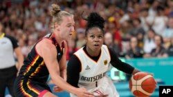 Alexis Peterson, of Germany, drives on Elisa Ramette, of Belgium, in a women's basketball game at the 2024 Summer Olympics, in Villeneuve-d'Ascq, France, July 29, 2024.