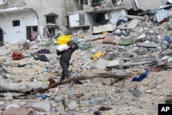 A Palestinian walks through the rubble left by Israel's offensive in Khan Younis, Gaza Strip, March 8, 2024.