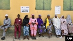 Voters sit as they queue to vote in Yola on Feb. 25, 2023 during Nigeria's presidential and parliamentary election.