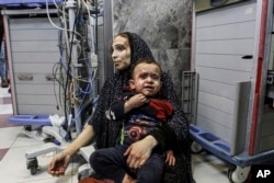 Wounded Palestinians wait for treatment in al-Shifa hospital in Gaza City, central Gaza Strip, after arriving from al-Ahli hospital following an explosion there, Oct. 17, 2023.