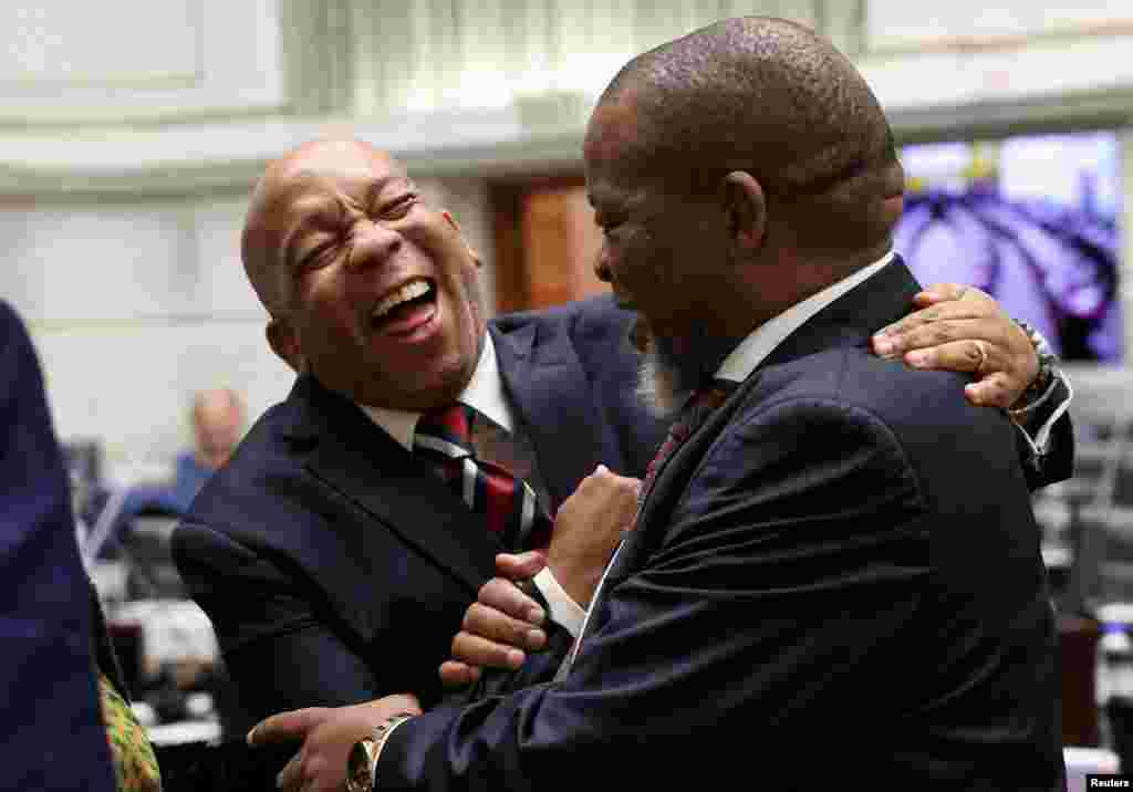 Minister of Mineral Resources and Energy Gwede Mantashe and Minister of Electricity Kgosientsho Ramokgopa react, ahead of a questions session in parliament, in Cape Town, South Africa.