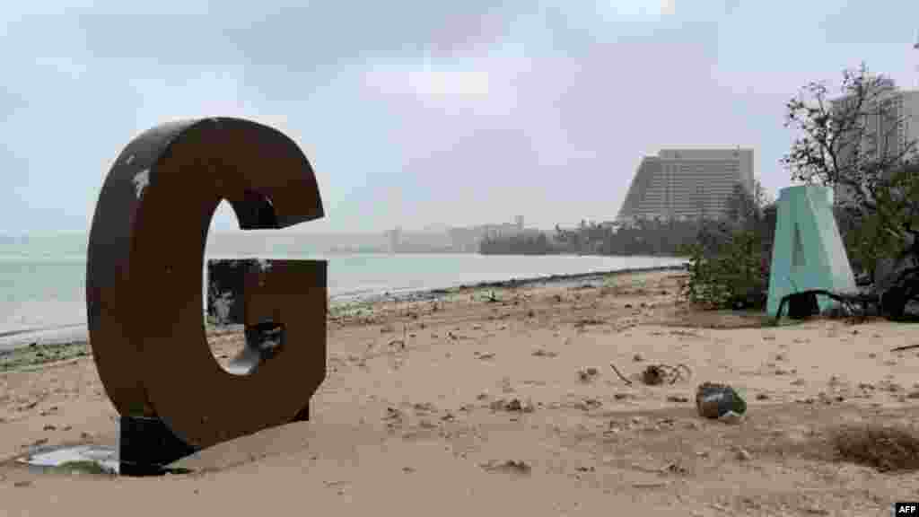 Џиновските букви што пишуваат ГУАМ, туристичко место на плажата, се расфрлани од силни ветрови и врнежи еден ден откако тајфунот Мавар помина над заливот Тумон, Гуам. (Фотографија од Џејмс Рејнолдс/Твитер/@EarthUncutTV/AFP)