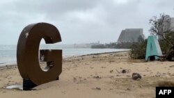 괌 해변의 사진촬영 명소로 꼽히는 대형 'GUAM(괌)' 표지 글자들이 태풍 '마와르' 영향으로 파손돼 25일 곳곳에 흩어져 있다. (영상 캡쳐=AFP PHOTO / James REYNOLDS)